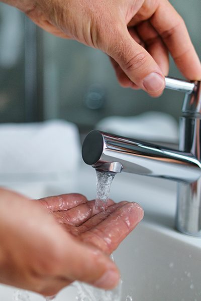person running hand under sink water humble tx